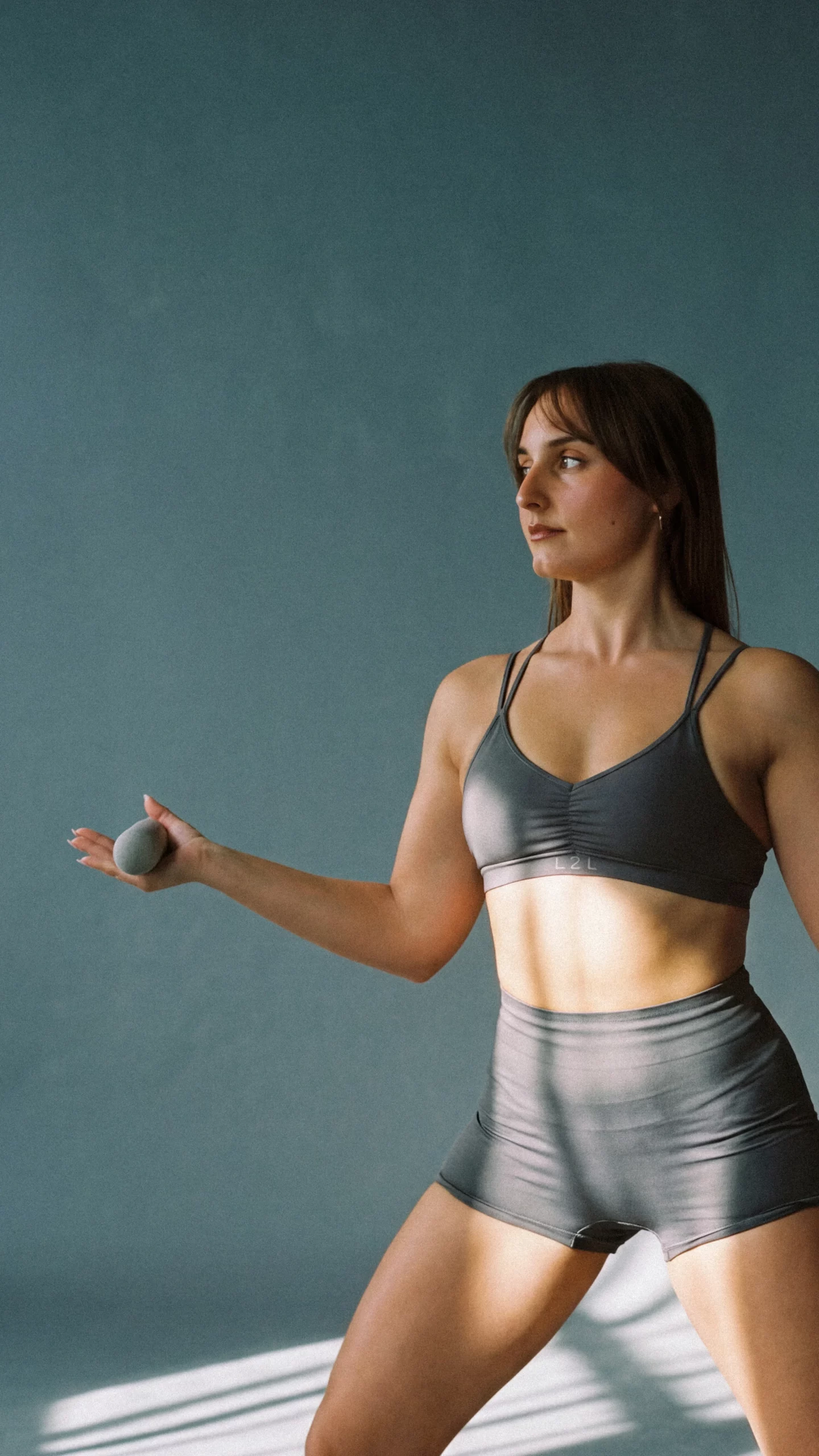 Mujer entrenando pilates de alto rendimiento con pesas